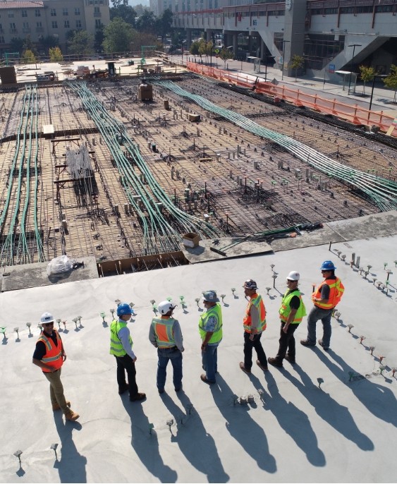 Baustelle von oben mit Bauarbeitern in einer Reihe